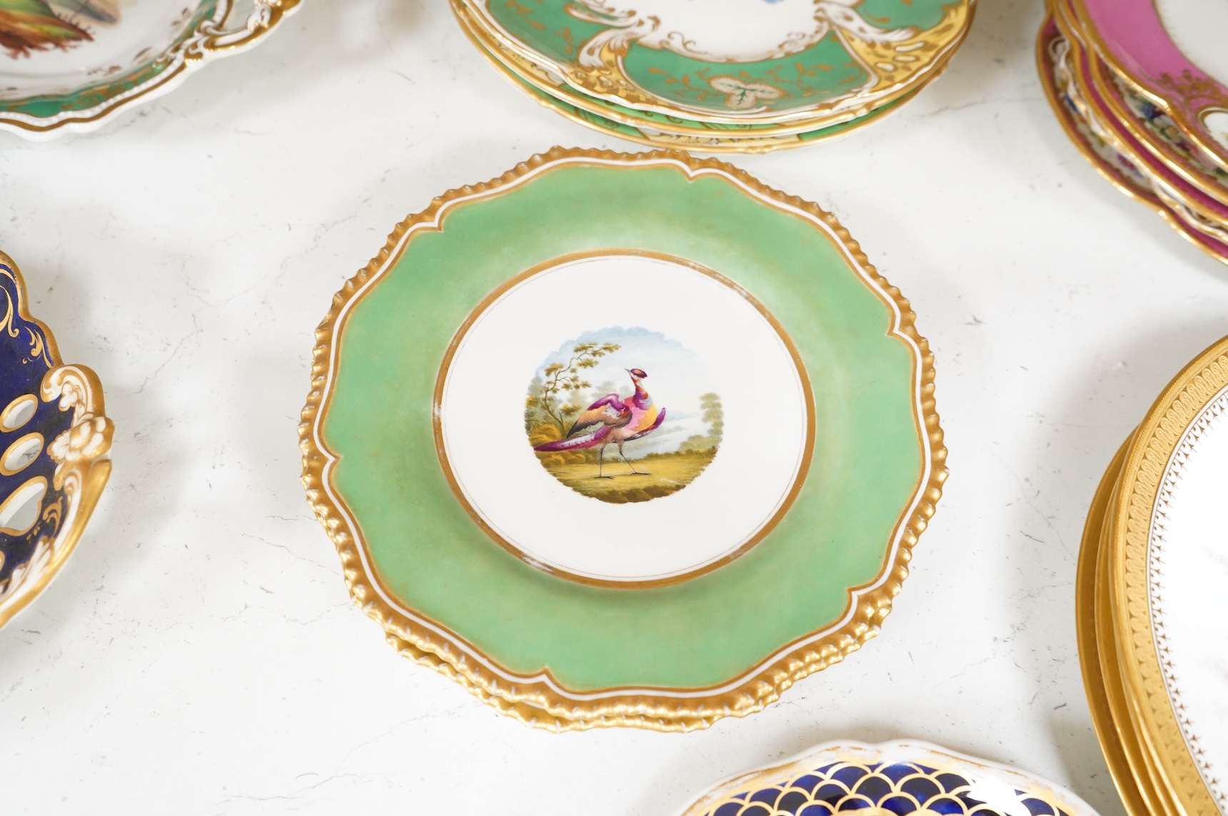 A collection of 19th century English dessert wares to include a pair of Flight, Barr and Barr ‘fantastic birds’ green ground dessert plates, various Ridgway dessert plates, five Minton botanical plates with tooled gilt b
